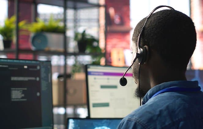 Support agent with a headset working at his computer